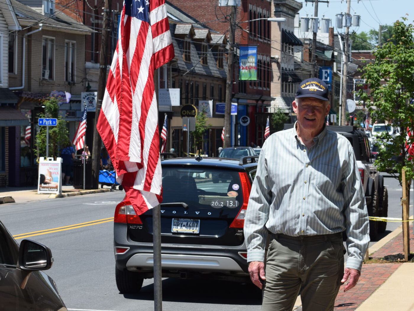 Hugh in the community on a flag-lined street